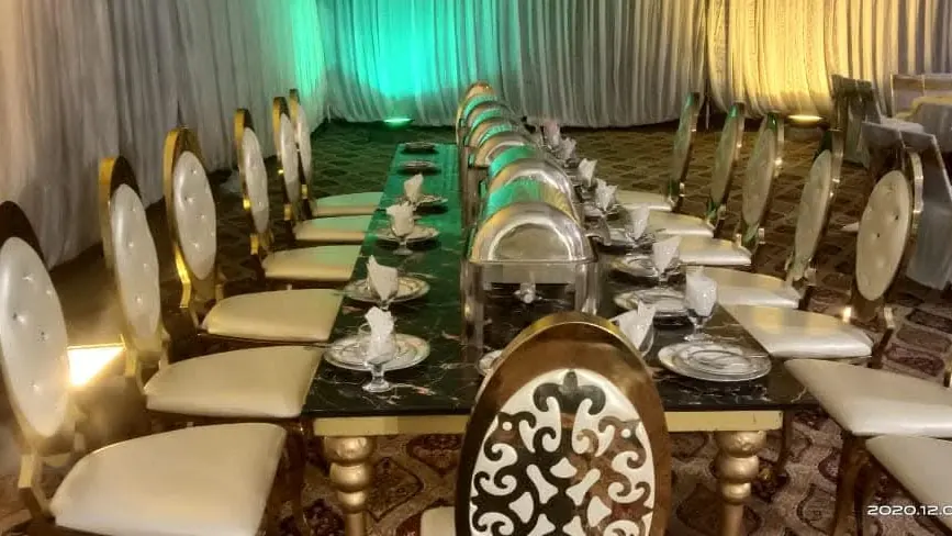 Gold chairs and chafing dishes set out for dinner